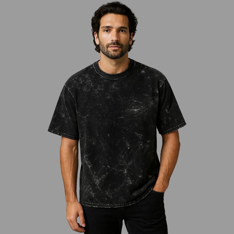 Man wearing a black distressed t-shirt against a gray background