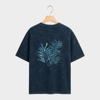 Black t-shirt with blue leaf design on a gray background