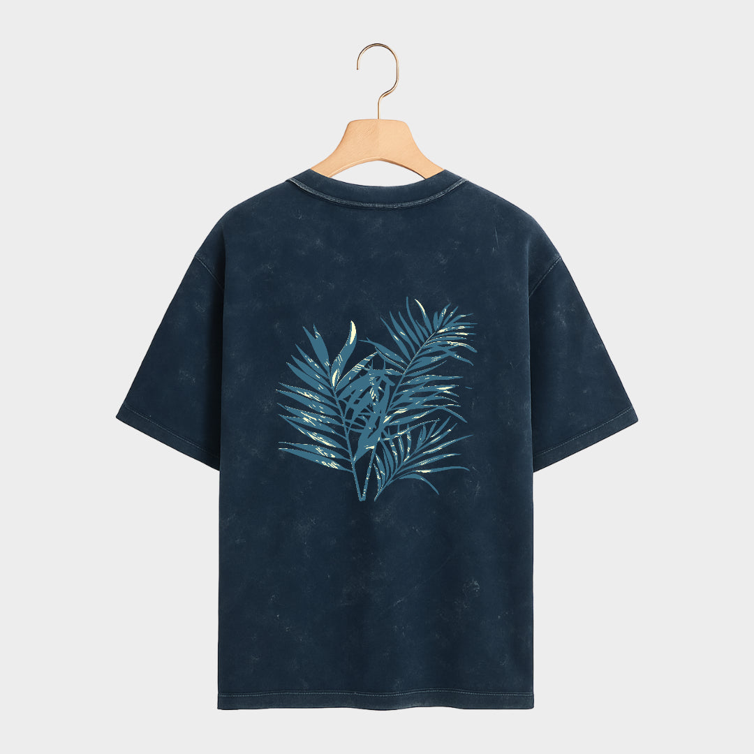 Black t-shirt with blue leaf design on a gray background