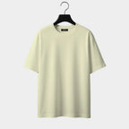Light yellow t-shirt on a hanger against a white background