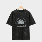 Black t-shirt with a white lotus flower design and text on a hanger against a white background