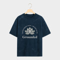 Navy t-shirt with white text and lotus flower graphic on a hanger against a light gray background