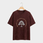 Brown t-shirt with a tree graphic and text on a hanger against a white background