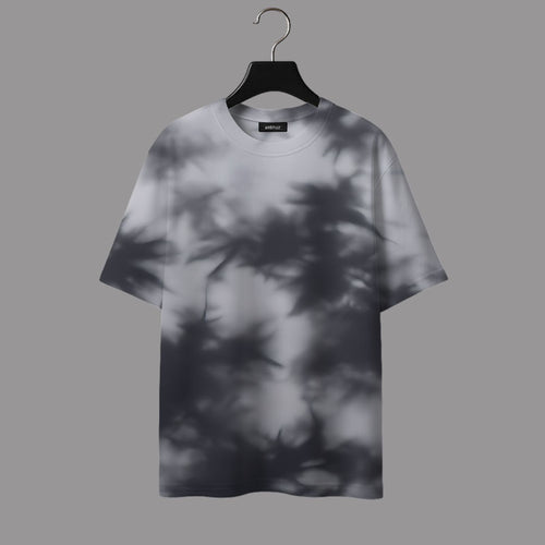 T-shirt with leaf shadow pattern on a hanger against a gray background
