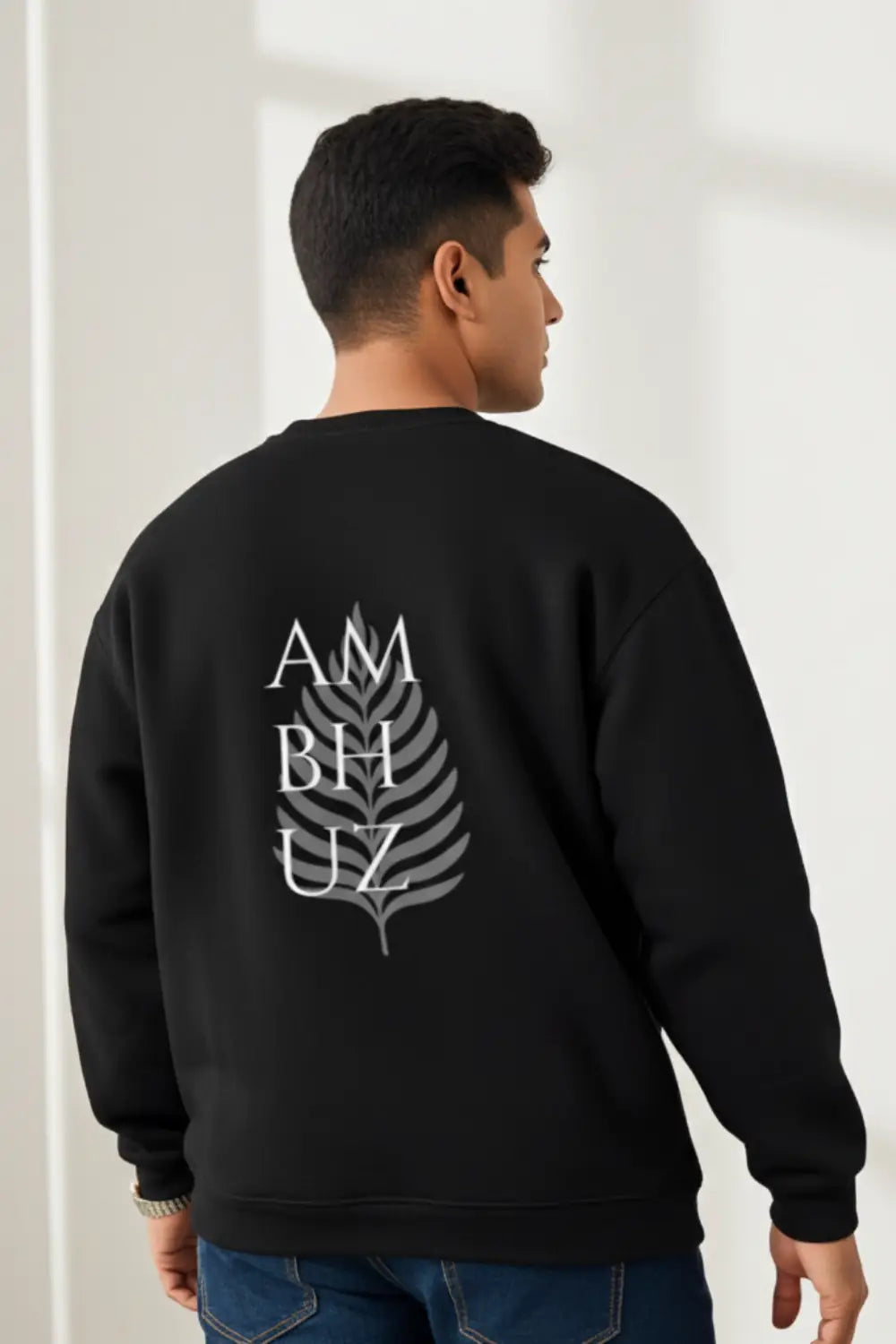 Person wearing a black sweatshirt with a design on the back against a white background